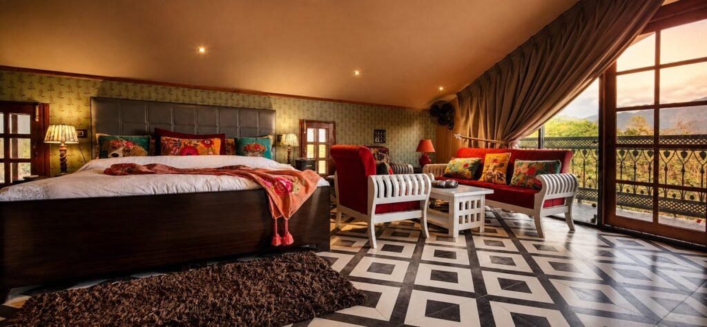 Master bedroom with sitting area and garden-facing doors at Amar Villas Dehradun by Around Stays
