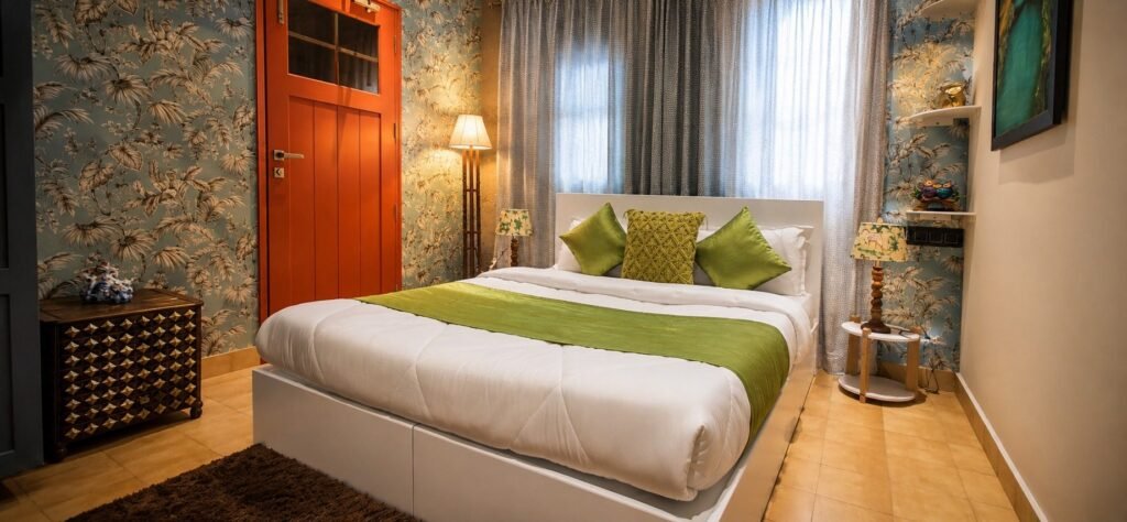 Bedroom with stone wall and green bedding at Amar Villas Dehradun by Around Stays