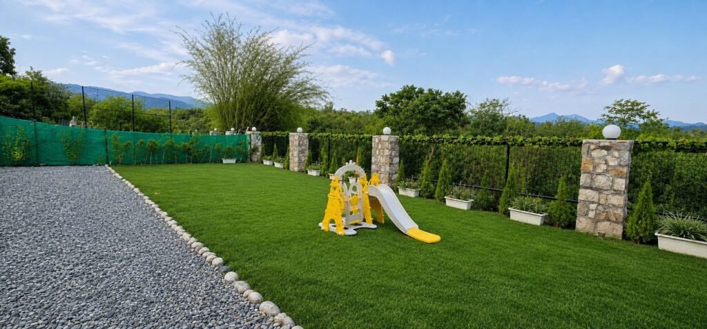 Large lawn with kids' swing and slide at Amar Villas Dehradun by Around Stays