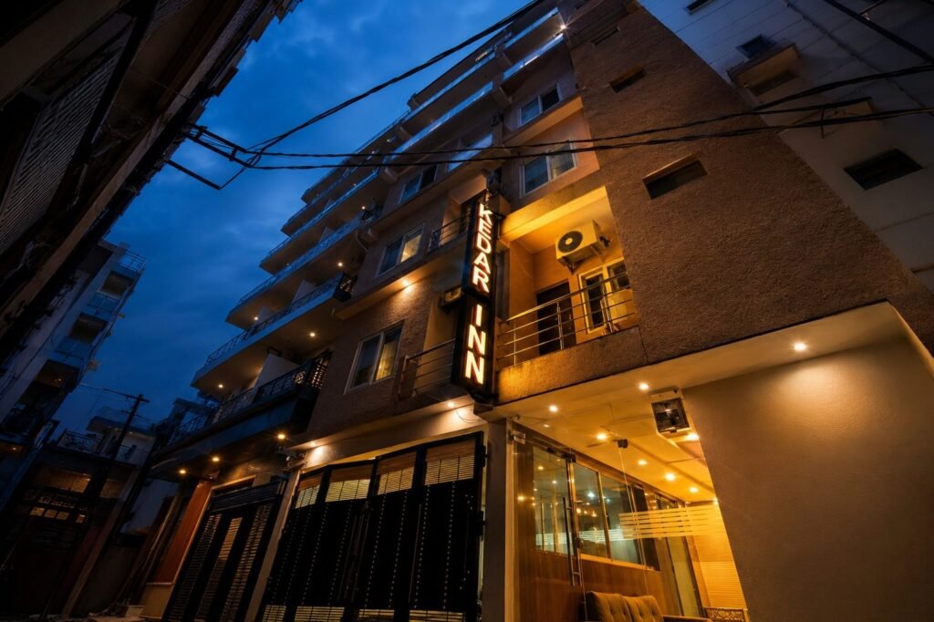 Hotel exterior lit up at dusk at Hotel Kedar Inn by Around Stays