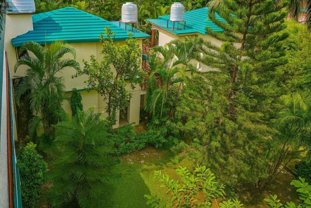 Garden courtyard with blue-roofed cottages amid lush greenery at Oslo Green by Around Stays