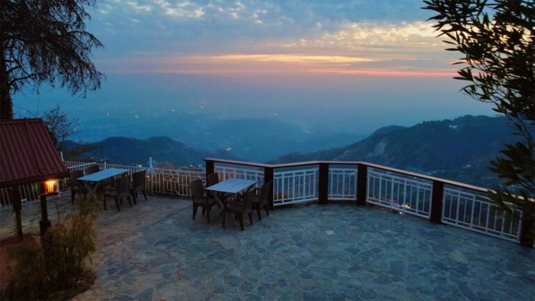 Open terrace at sunset over the valley at Oslo Mussoorie by Around Stays