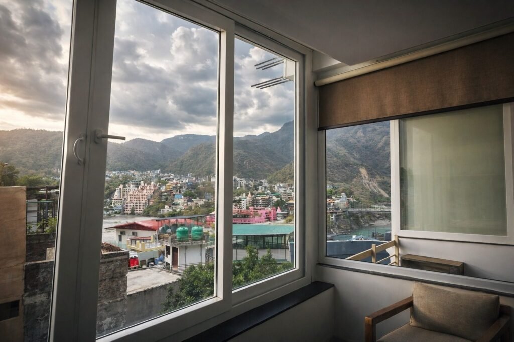 Room with a large window framing the mountains at Rishikesh Heritage Resort by Around Stays