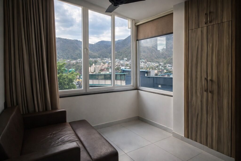 Corner seating with windows overlooking the hills at Rishikesh Heritage Resort by Around Stays