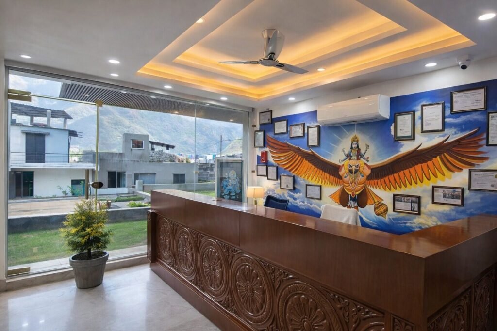 Reception desk with a Garuda mural at The Great Garuda by Around Stays